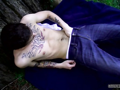 Tattooed twink masturbating his dick while outdoor