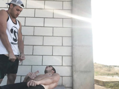 Strong hunk is lying on sidewalk and pleasantly jerking off his gay dick